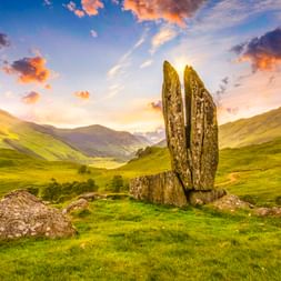 Zwei hohe aufrechte Steinplatten bilden das Monument Betende Hände Mariens in den grünen schottischen Highlands bei Aberfeldy bei Sonnenuntergang.