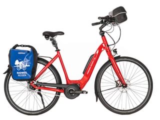 Rotes Tiefeinsteiger-E-Bike mit schwarzem Sattel, Lenkertasche und blauer Radweg Reisen Packtasche am Gepäckträger, vor weißem Hintergrund.