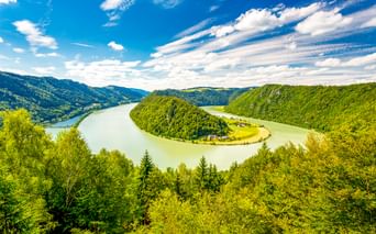 Luftaufnahme der Donauschlinge Schlögen, wo die Donau eine dramatische Hufeisenschleife um eine bewaldete Halbinsel in Österreich bildet.