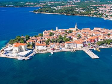 Luftaufnahme der Halbinsel Poreč mit historischer Altstadt, roten Ziegeldächern, Kirchturm, Hafen und tiefblauem Adriatischem Meer.