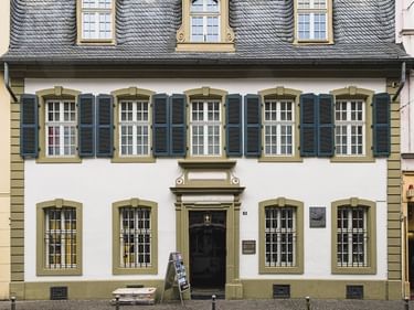 Weißes Barockhaus mit dunklen Fensterläden und Schieferdach in Trier, Geburtshaus von Karl Marx, heute Museum.
