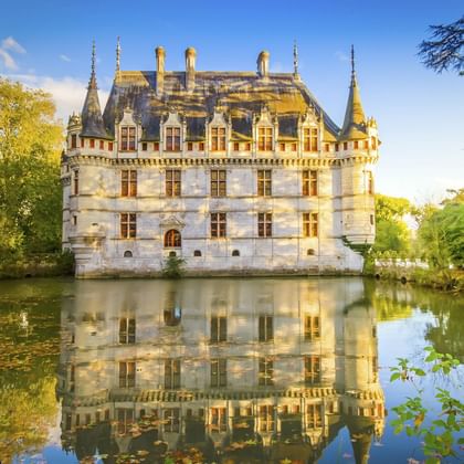 Schloss Azay-le-Rideau, ein weißes Renaissance-Schloss mit Türmchen und steilen Dächern, von Wasser umgeben mit perfekter Spiegelung.