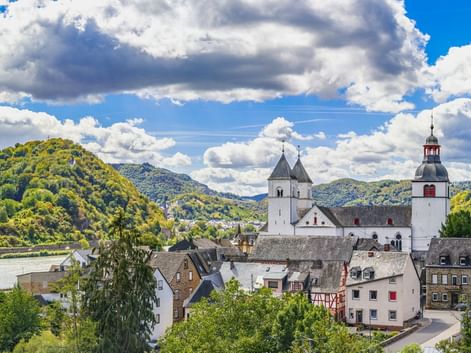 Panoramablick auf das Dorf Treis-Karden an der Mosel mit der St. Castor Kirche mit weißem Turm und rot bedachtem Glockenturm.