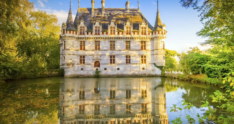 Schloss Azay-le-Rideau, ein weißes Renaissance-Schloss mit Türmchen und steilen Dächern, von Wasser umgeben mit perfekter Spiegelung.